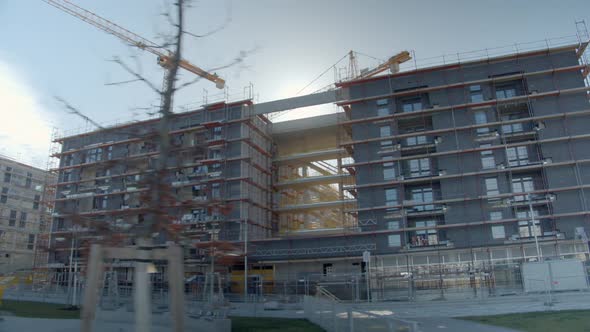 Exterior Of Unfinished Buildings With Tower Cranes In Background. low angle, arc shot