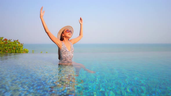 Young asian woman enjoy around outdoor swimming pool for leisure