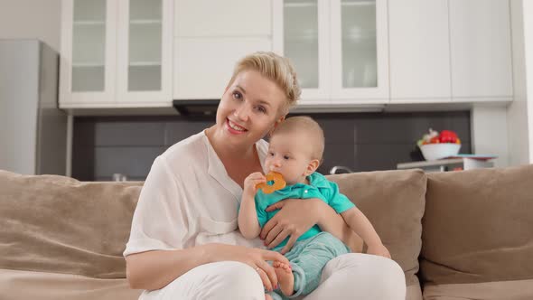 Smiling Woman Holding Toddler and Having Video Call