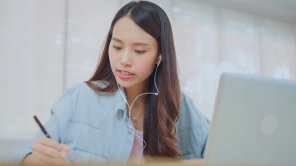 Asian Beautiful school girl use laptop study virtual online, watching internet video course at home