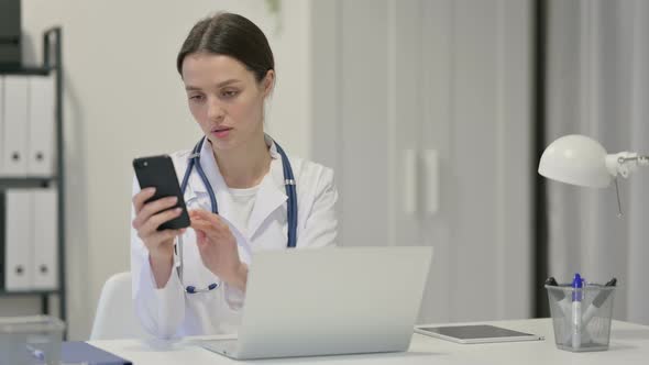 Female Doctor with Laptop Using Smartphone 
