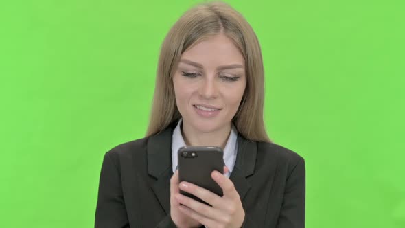 Young Businesswoman Using Smartphone Against Chroma Key