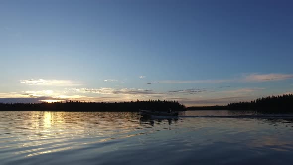 Boat sailing on lake at sunset