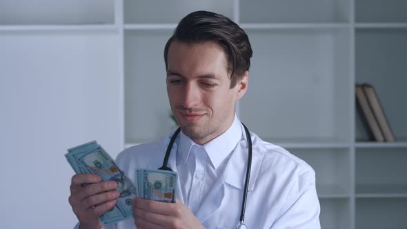 Portrait of Corrupted Male Medical Doctor Counting Money