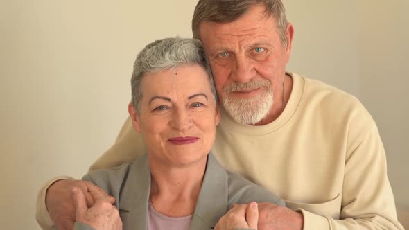 Close Portrait of Smiling Elderly Husband and Wife Looking at Camera