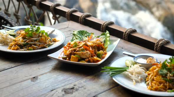 Traditional Asian Outdoor Cafe with Thai Food with Nature Waterfall Background