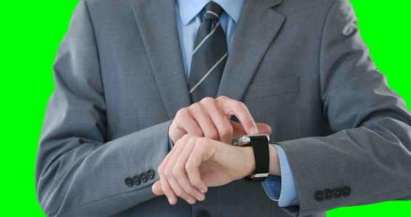 Mid-section of businessman using smartwatch