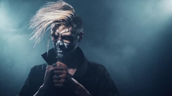 Gothic Man with Provocative Hairstyle and Horror Paint on Face Standing Standing Alone and Posing