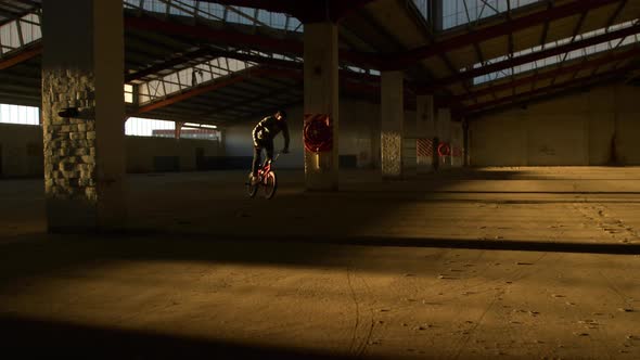 BMX rider in an empty warehouse