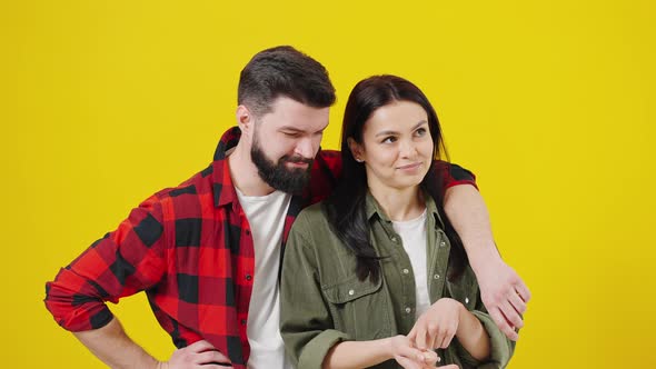 The Guy and the Girl are Embracing on a Yellow Background