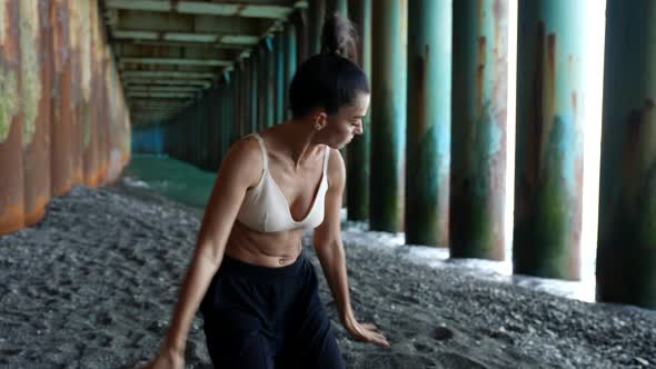 Street Style Dance Under Pier Young Woman is Dancing Alone on Sea Coast at Summertime