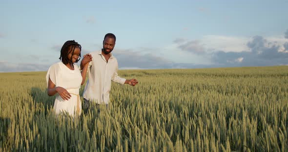 Young Black Couple Walking Through Green Field