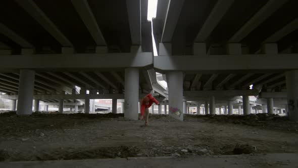 Parkourist Performing Stunts under Urban Bridge