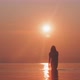 Silhouette of a woman walking in a calm sea towards the camera - VideoHive Item for Sale