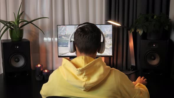 Professional gamer in headphones playing in first-person shooter online video games