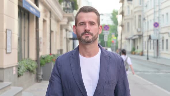 Close Up of Man Walking Towards Camera in Street