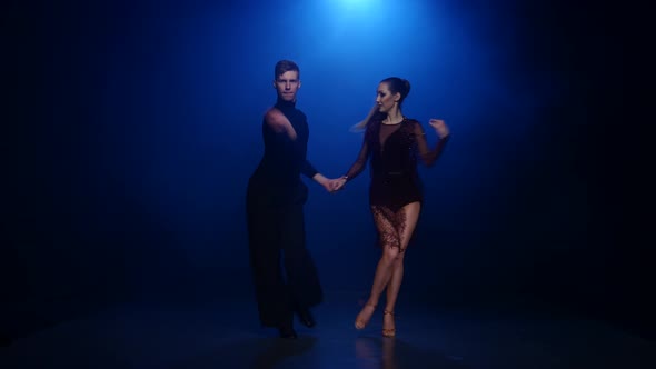 Jive Dancing Couple of Professional Elegant Dancers in Smoky Studio