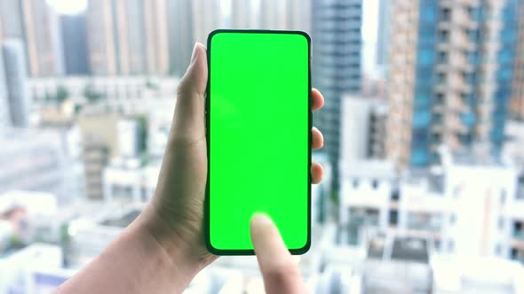 Male hands using smartphone with green screen.