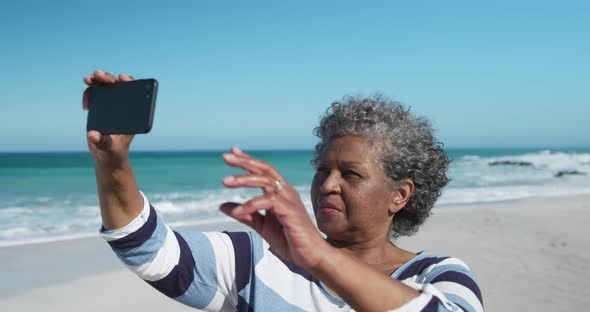 Senior woman taking photos at the beach