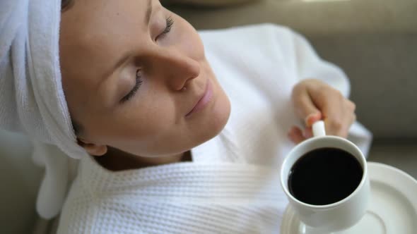 Woman Smelling Coffee In Bathrobe After Morning Shower