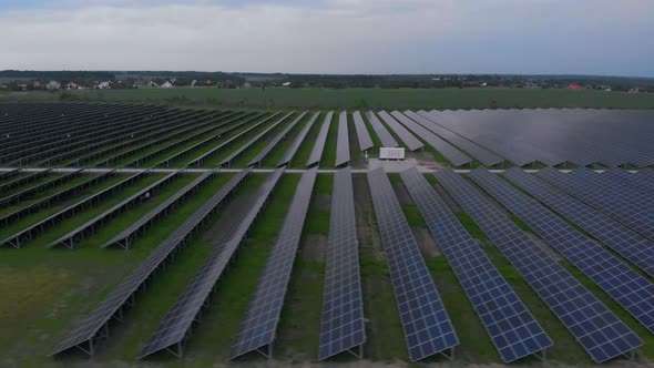 Aerial Drone View Into Large Solar Panels at a Solar Farm at Cloudy Summer Evening. Solar Cell Power