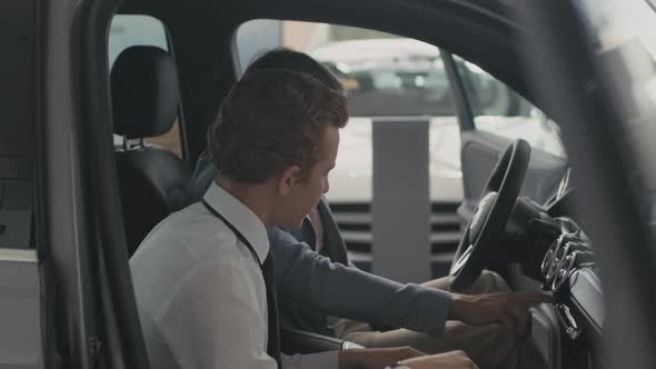 Salesman Showing Car Interior to Customer