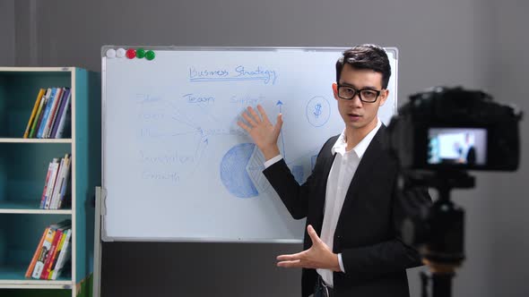 Asian Businessman Presenting In Front Of Camera