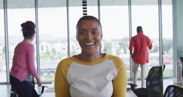 Smiling african american creative businesswoman in office, with diverse colleagues in background