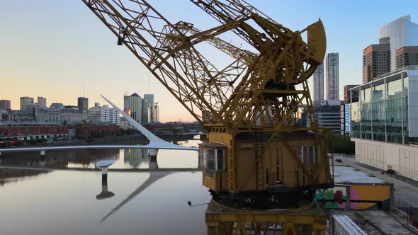 Aerial dolly left revealing two old port cranes in Puerto Madero waterfront at sunset