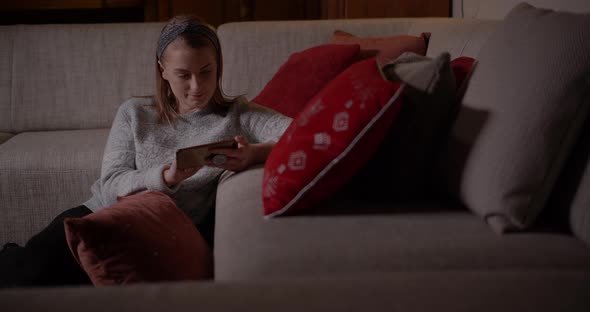 Woman Browsing Social Media on Smartphone at Home