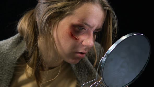 Woman Looking at Wound in Mirror, Feels Desperate to Stop Domestic Violence