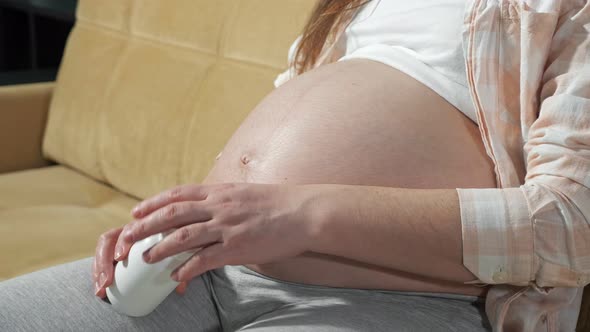Unrecognizable Pregnant Woman Puts Capsules on Hand Taking Vitamins for Pregnant Women