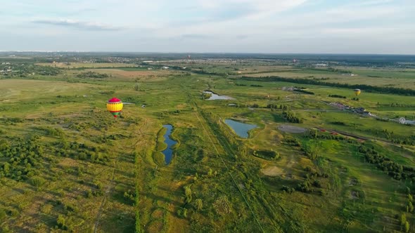 Colorful hot air balloon. Aerial view of air balloon over fields