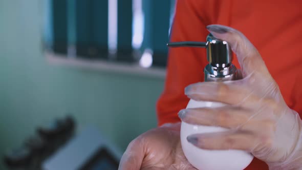 Doctor in Gloves Cleans Hands with Antiseptic Closeup