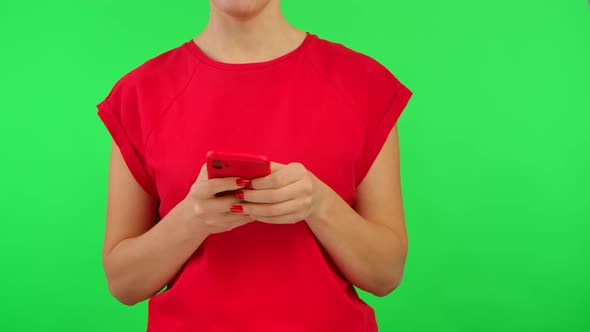 Woman in Red Tshirt Texting on Smartphone and Demonstrates Phone with Workspace Mock Up Screen on