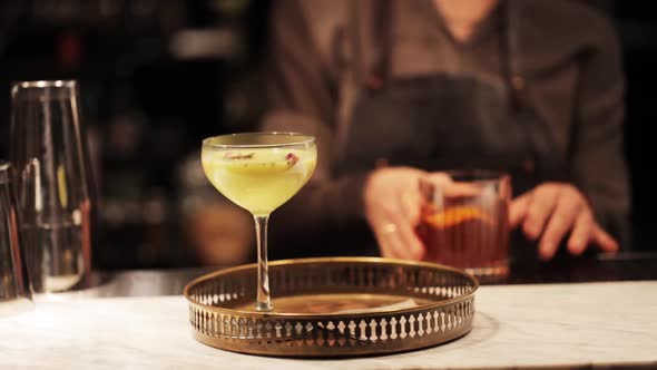 Bartender with Glasses of Cocktails at Bar