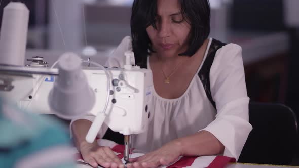 Zoomed view of hispanic woman working with sewing machine