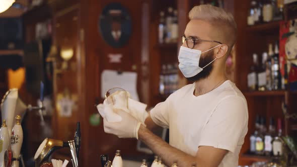 Bartender Wearing Face Mask and Gloves Cleaning Empty Glass