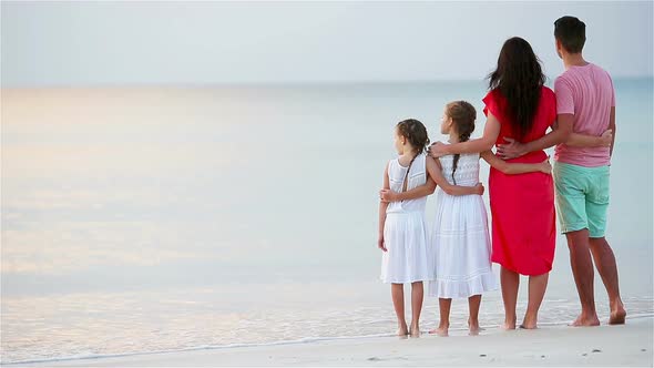 Young Family of Four on Beach Vacation on the Sunset