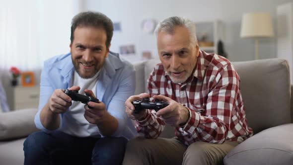 Two Adult Men Winning Video Game Giving High-Five, Celebrating Victory, Leisure