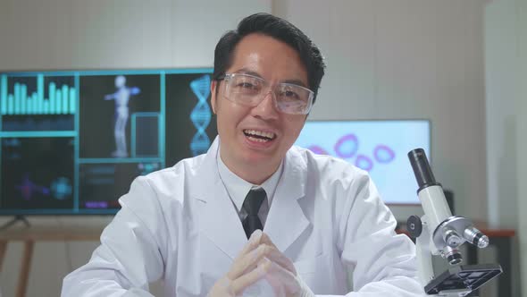 Asian Scientist Researching In The Laboratory With A Microscope And Speaking To The Camera