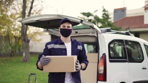 Handsome Courier Takes Cardboard Box Package Out of Delivery Van Walks Through Private Sector