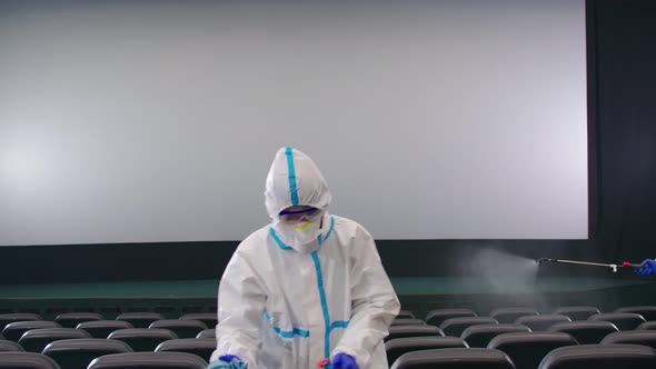 Workers Cleaning Cinema Hall with Special Disinfectants