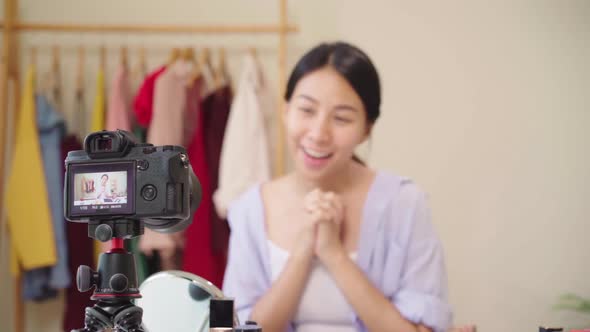 Beauty blogger present beauty cosmetics sitting in front camera for recording video Asian woman.