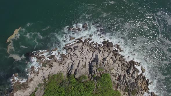 View From a Drone Vertically Down on a Stone Cape Washed By Strong Waves