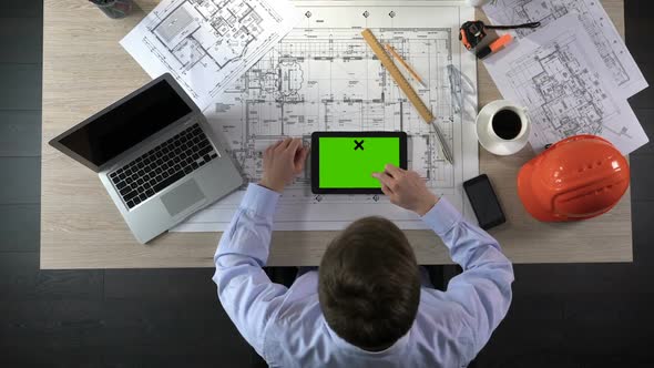 Professional Architect Viewing Apartment Photos on Green Screen Tablet, Top View
