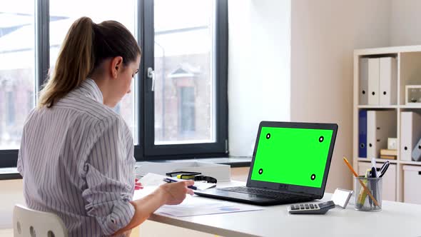 Woman with Laptop and Papers Working at Home