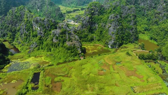 Aerial: North Vietnam karst landscape at sunset, drone view of Ninh Binh region, tourist destination