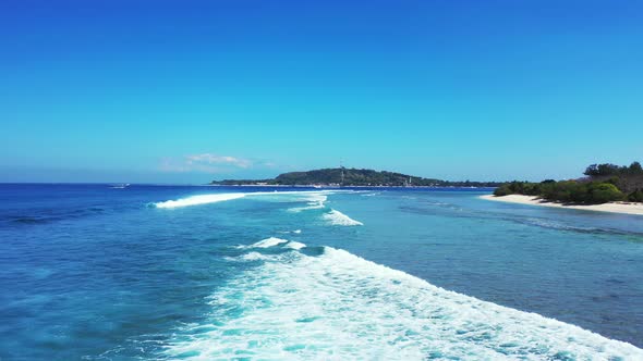 Wide angle aerial travel shot of a white sand paradise beach and aqua blue ocean background in hi re