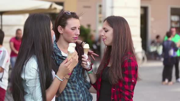 Three happy women eating ice cream in the city